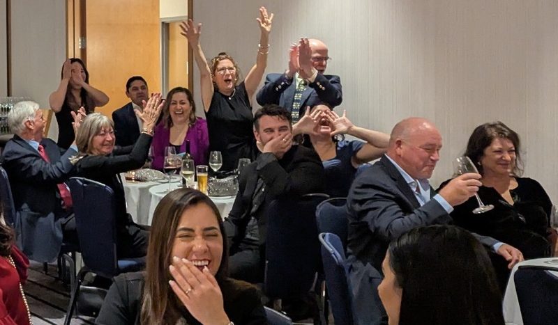 A crowd cheering with hands raised during a Pop Trivia corporate event