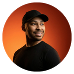 Profile headshot of Lionel set against a warm orange backdrop.