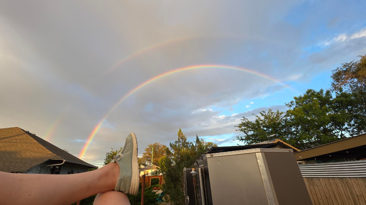 gorgeous doublt rainbow over the hobo house with a view of my cool shoes as I sit cross-legged on the roof rack of the SUV after a summer storm.